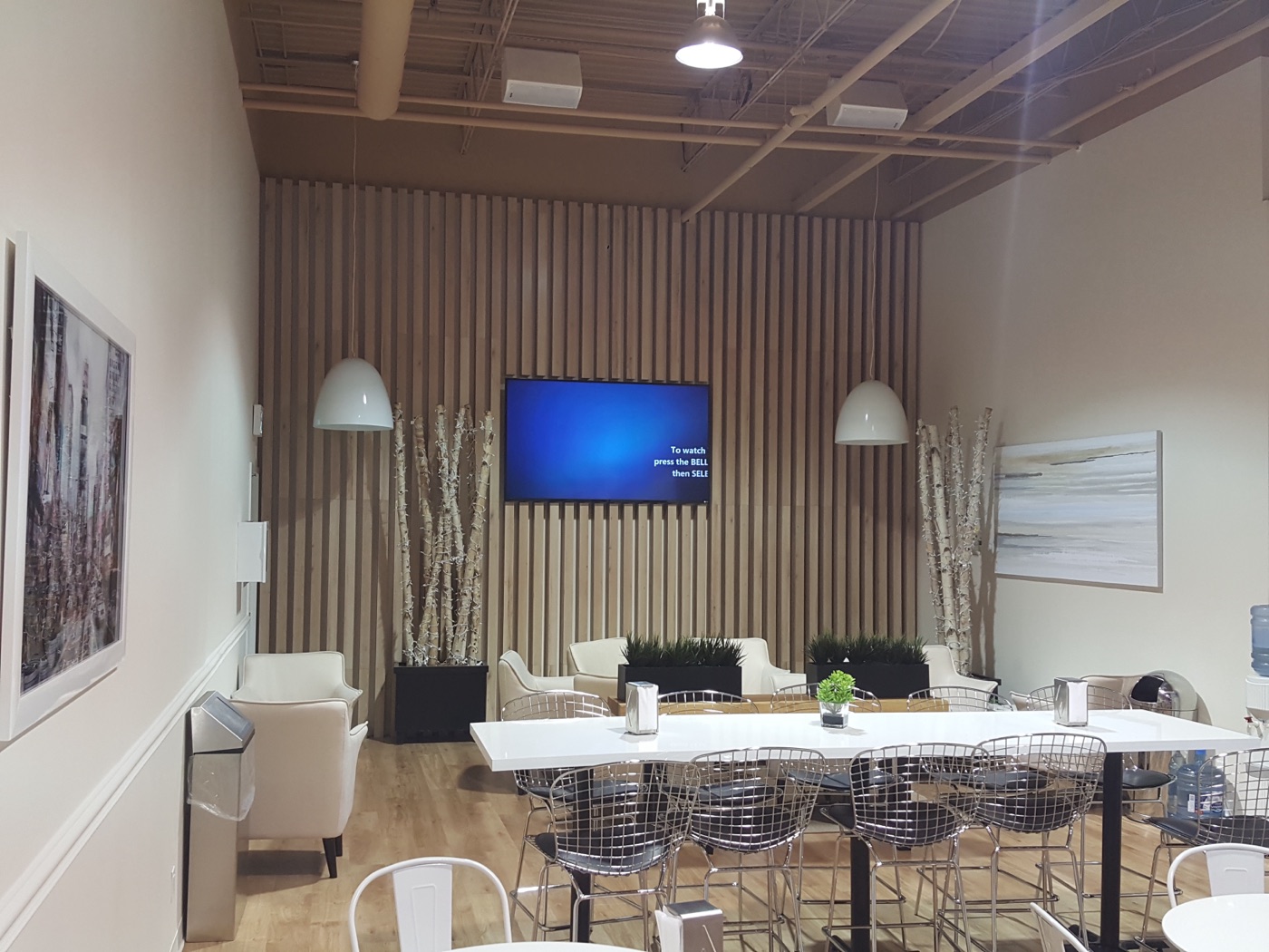 CNFL commercial lounge with custom wood slat feature wall, integrated TV millwork, and built-in cabinetry