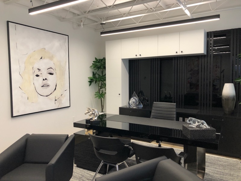 YM Inc executive office with custom high-gloss black cabinetry, slatted panel wall, and bespoke desk millwork by Leewood Finishing