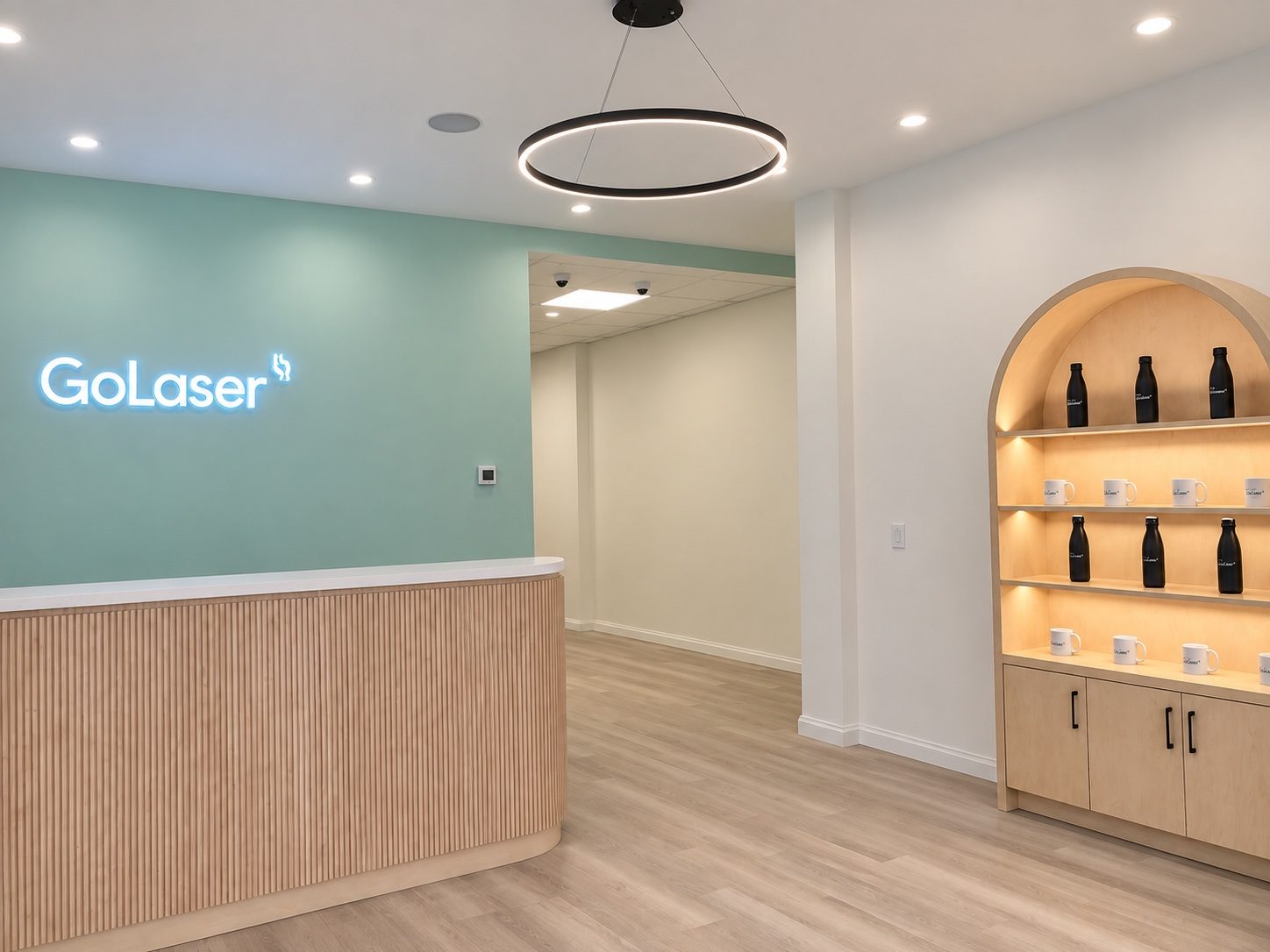 Clinic reception with a fluted wood reception desk and an arched display cabinet built by Leewood Finishing