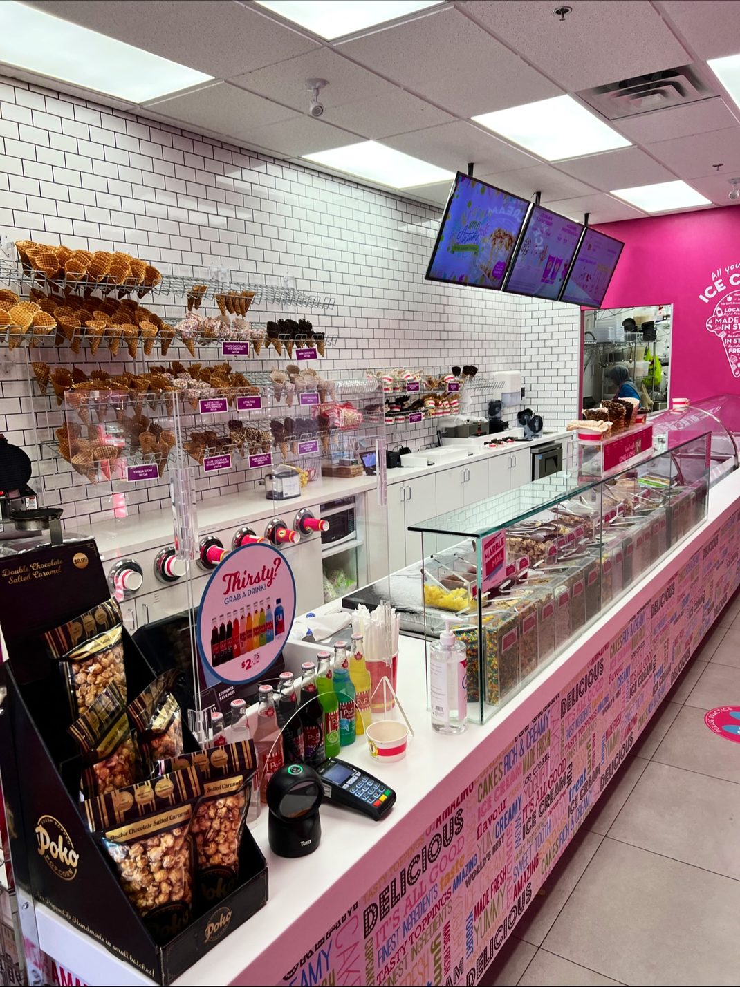 Back counter of an ice cream shop in Oakville, with counter cabinets and white countertops built by Leewood Finishing