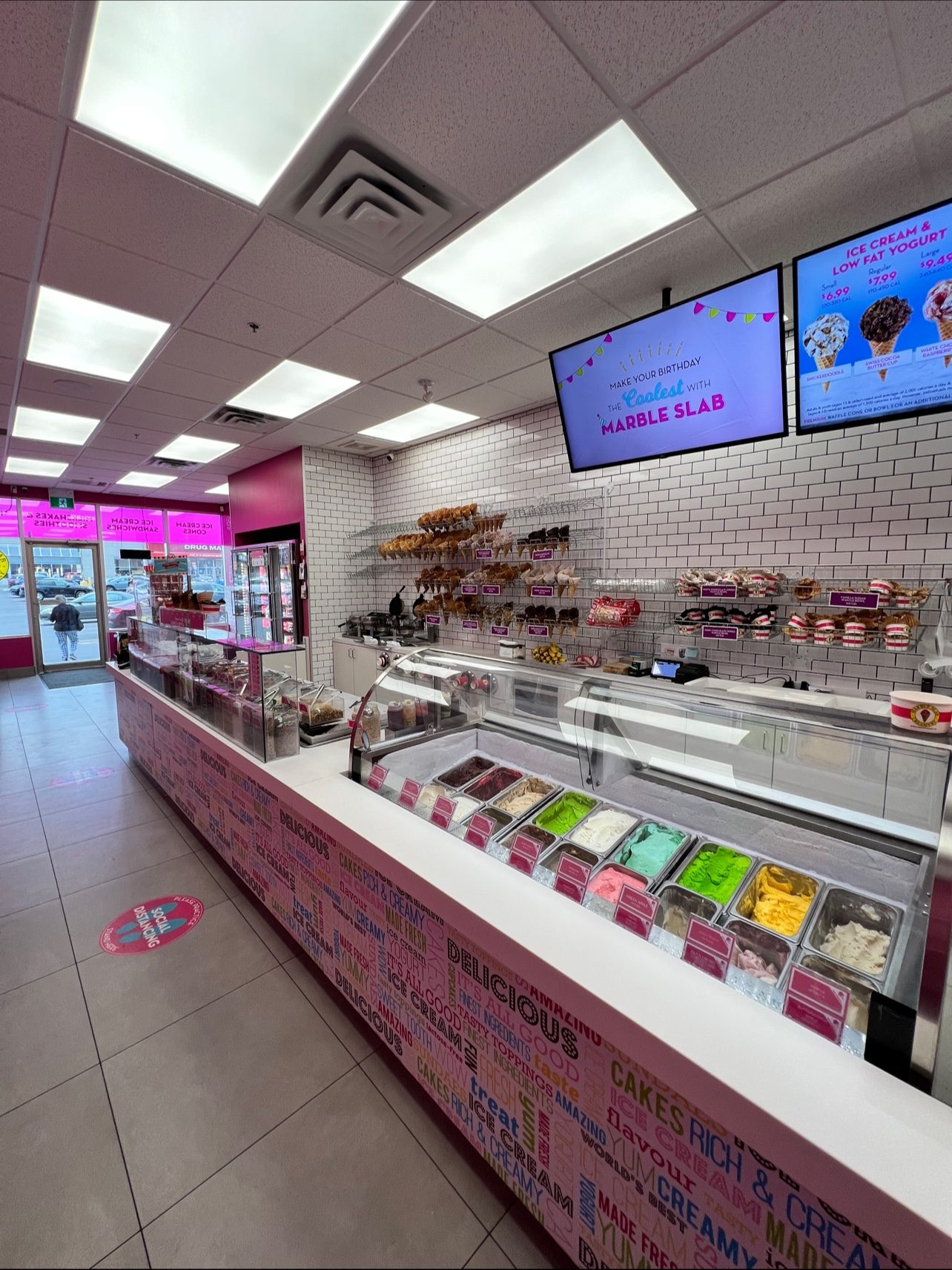 Long service counter in an Oakville ice cream shop with cabinets and a solid-surface countertop built by Leewood Finishing