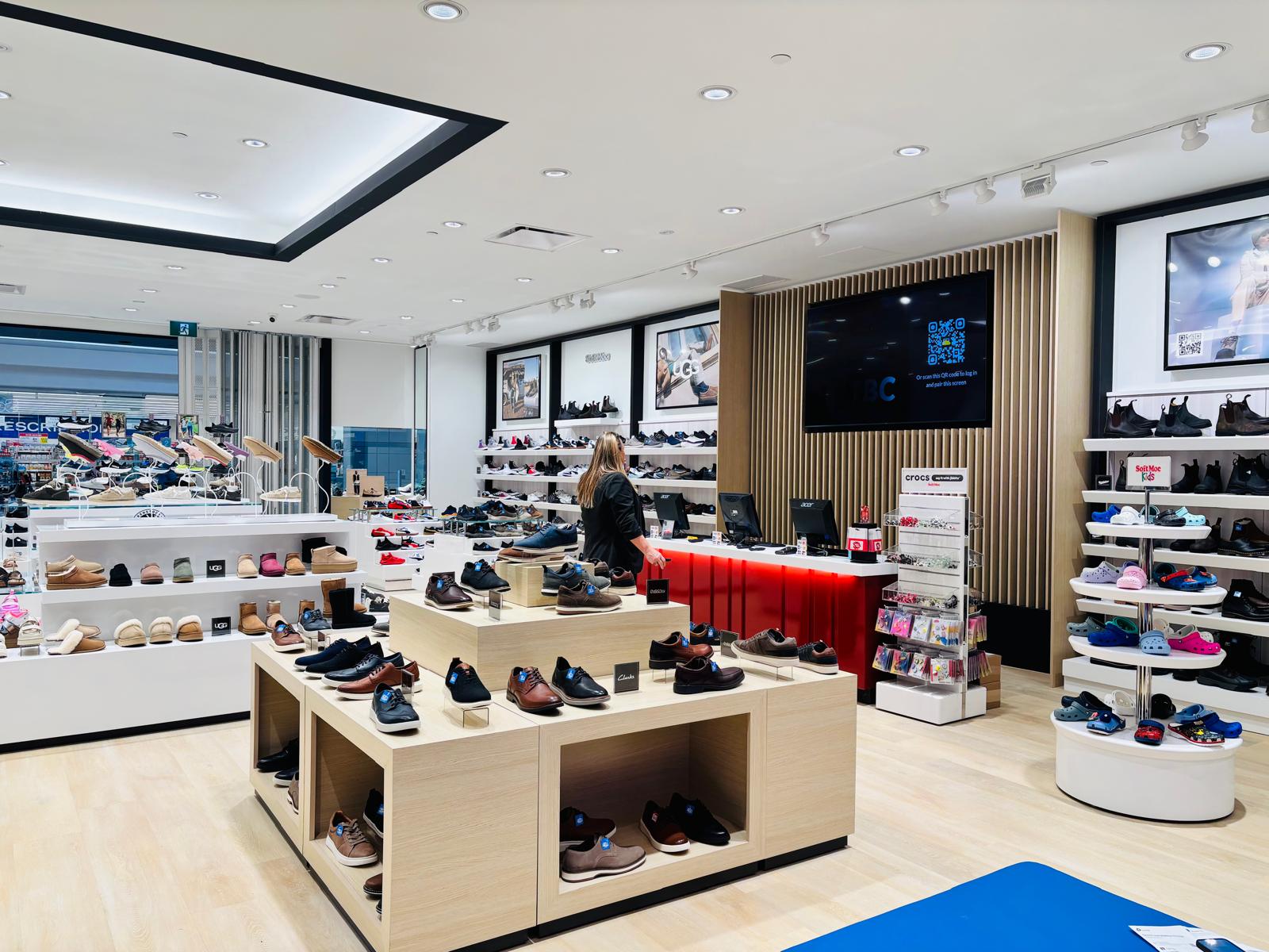 Softmoc retail store interior with custom slatted wood display fixtures and millwork built by Leewood Finishing
