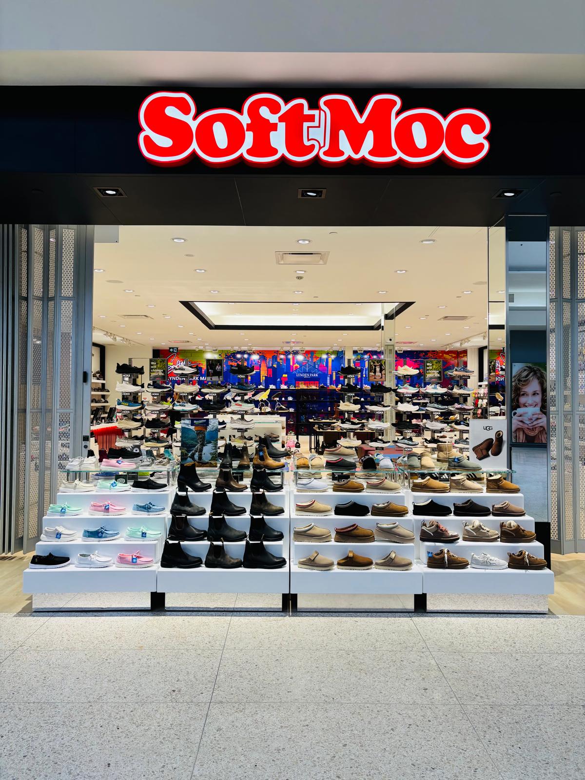 Retail storefront with a tiered white display fixture presenting footwear at the store entrance, built by Leewood Finishing